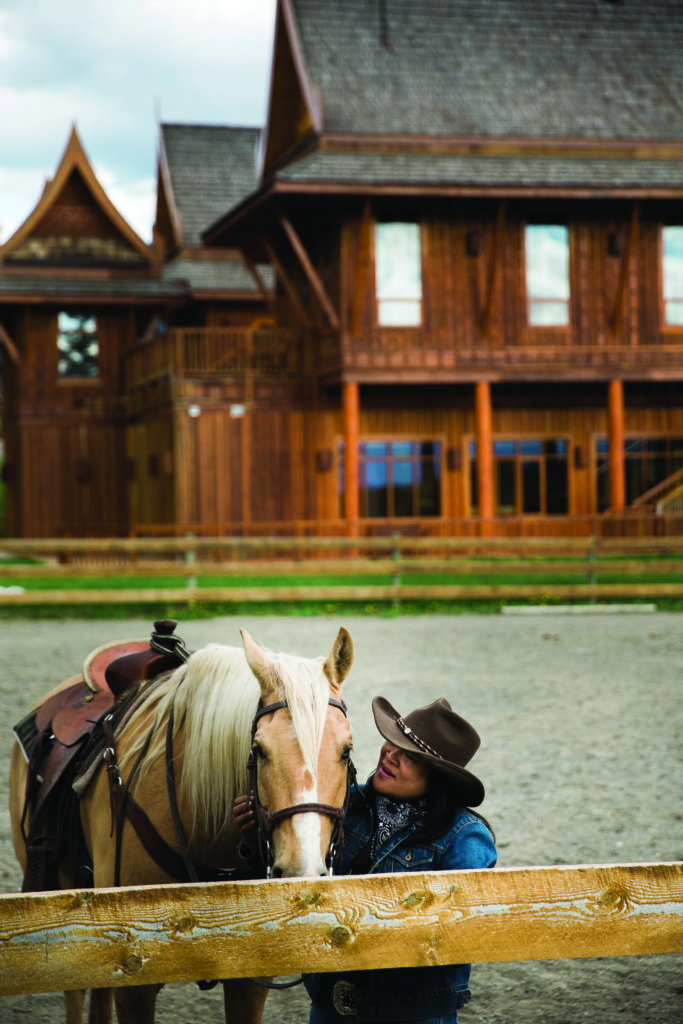 A women stands next to a horse outside of the Echo Valley Ranch & Spa.