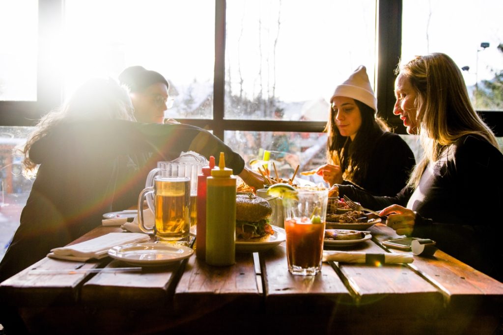 Four people sit at a table enjoying Apres at Whistler Blackcomb