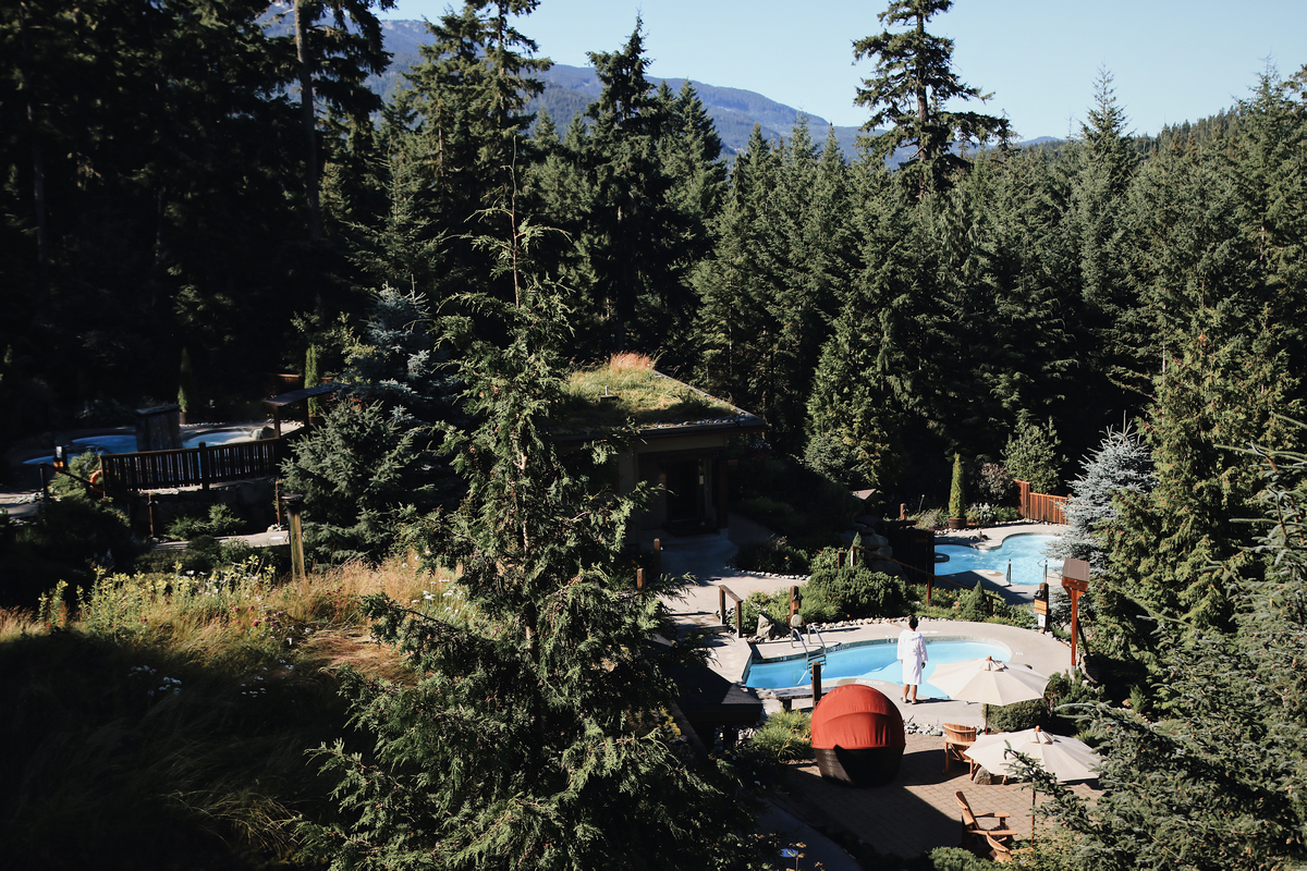 Scandinave Spa Whistler as seen from above. One bather in a bathrobe approaches the one of the pools.