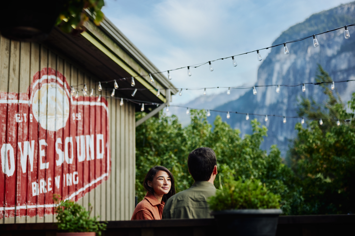 Two people sit on a patio at Howe Sound Inn & Brewing